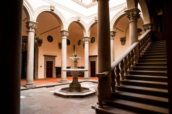 The internal courtyard of Palazzo Gondi, featuring an arcaded loggia with columns and a central fountain.